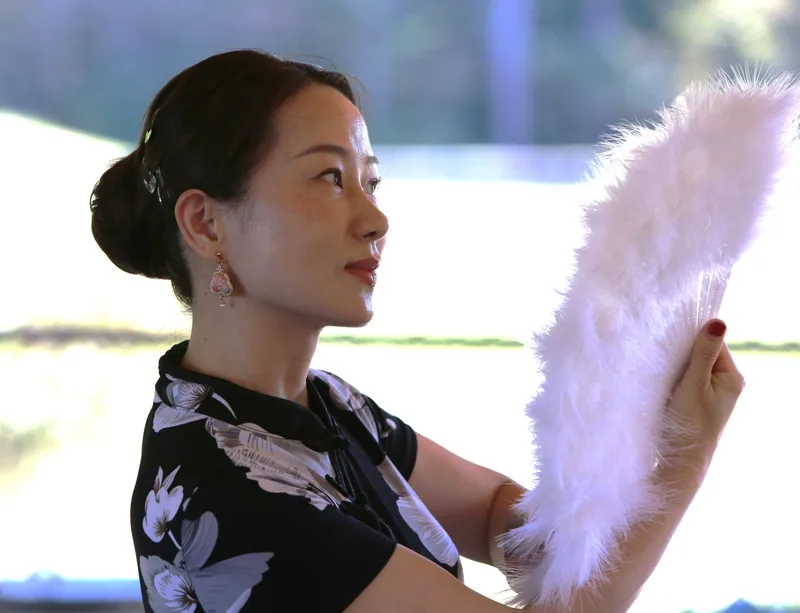 手持白色羽扇的侧影